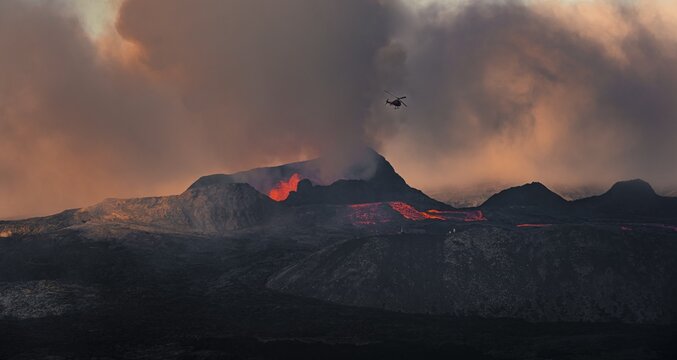 Helicopter flying over erupting volcano with lava fountains and lava field, crater with erupting lava and lava flow, Fagradalsfjall, Kr&yacute;suv&iacute;k volcano system, Reykjanes Peninsula, Iceland
