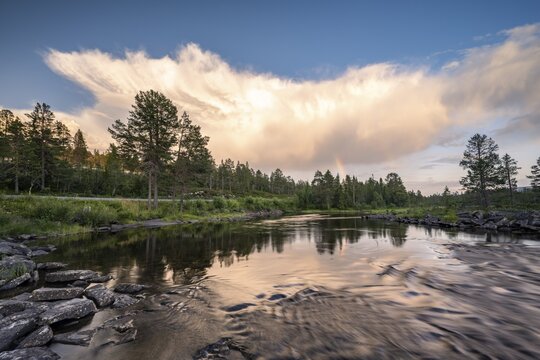 Cloudy atmosphere and rainbow over lake Kjerringvatnet, Nordland, Norway
