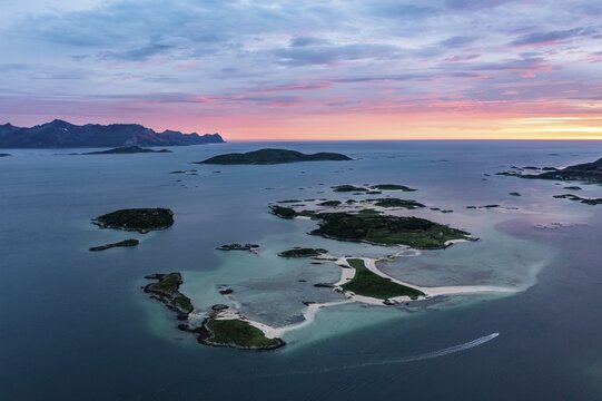 View of small islands in the sea near Sommar&oslash;y, mountains of Senja Island in the back, aerial view at sunset, Kval&oslash;ya, Troms og Finnmark, Norway