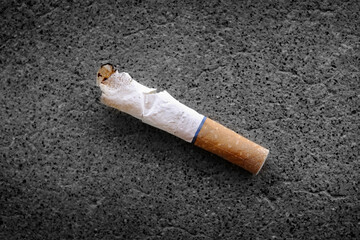 Old Used Cigarette Butt on Concrete Sidewalk Discarded and Thrown Away as Trash Unhealthy Addiction