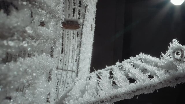 Wide view frosted stair and railing, glittering hoarfrost coats metal balustrade and adjacent lattice, pale sun halo and lens glare, chill monochrome tone, abandoned urban setting evoking nuclear