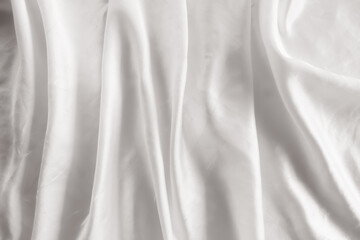 Elegant white silk fabric background with soft ripples and shadows. Smooth satin cloth texture for...