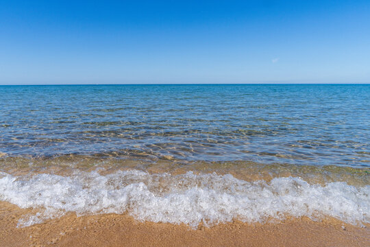 Small wave breaking on sandy Lake Michigan beach near Holland Michigan