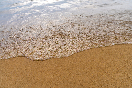 Beach wave foam meeting sand texture shoreline on Lake Michigan