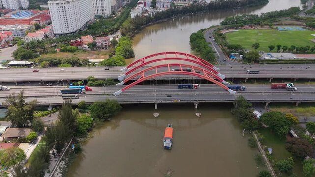 Aerial view of Ong Lon Bridge on Nguyen Van Linh Boulevard with urban traffic and canal, modern infrastructure scene in Ho Chi Minh City