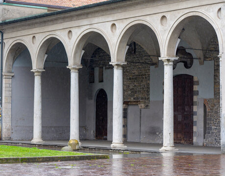 Elegant cloister corridor with a row of stone columns and arches forming a classic arcade in a historic Italian religious building, reflecting traditional architecture and heritage.