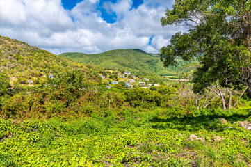 Obraz premium A view from the coastal road towards a hillside village near Curtain Bluff in Antigua on a bright sunny day