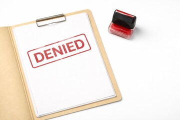 Clipboard displays denied stamp on paper with red ink pad, concept of rejection © dvoevnore