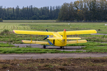 Yellow retro passenger biplane at the airfield © Dushlik