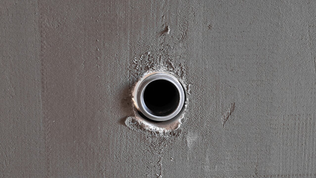 Round Conduit Hole In Wall, Inspector Documenting Penetration During House Construction Closeup Of Circular Opening With Mortar Edges And Raw Plaster Texture, Practical View For Site