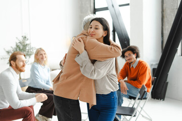 Fototapeta premium Portrait of young hipster, woman hugging sad patient while therapy, session