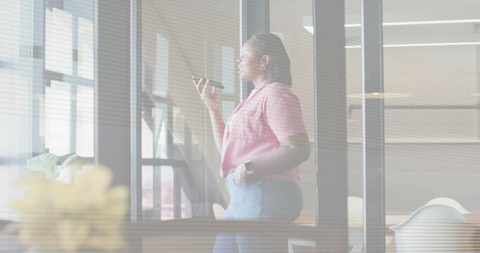 Reflections fading, woman holding phone, raising it, taking call, turning toward window in business