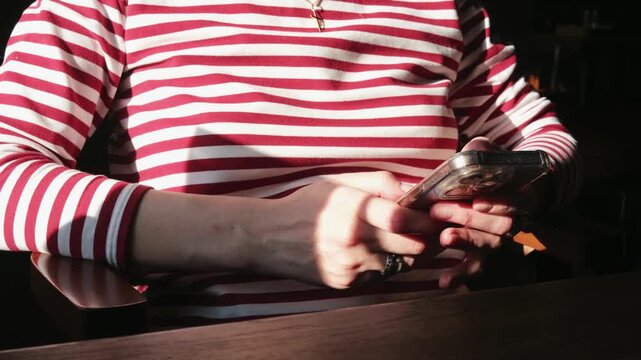 Woman using smartphone and actively scrolling on mobile screen. Close view of hands browsing social media, playing mobile game, chatting or reading news on phone.