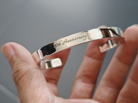 silver bracelet engraved text 10th anniversary on hand. mirror polishing