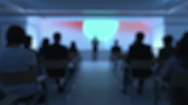 Blurred audience at a conference listening to a speaker on stage. Engaging presentation fostering knowledge sharing and professional development