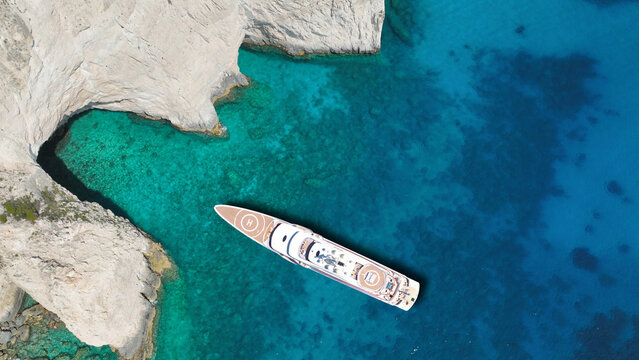 Aerial drone top down photo of luxury yacht anchored in paradise island bay with turquoise crystal clear sea