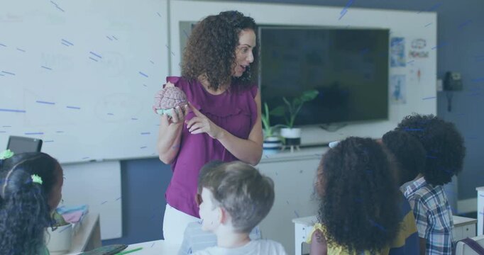 Female teacher holding brain model, pointing and turning sections while teaching classroom anatomy