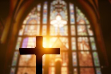 Silhouette of wooden cross inside antique church