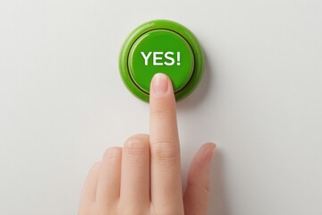 Human hand pressing a green push button labeled YES against a plain white background, emphasizing the action of confirmation or agreement in a minimalistic setting
