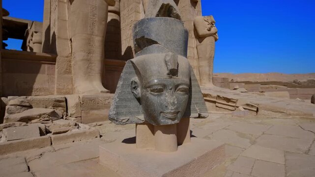 Ruins of Ramesseum mortuary temple with giant Ramesses II Osiride statues. It is located in the Theban necropolis in Upper Egypt, across the River Nile from the modern city of Luxor. Egypt.