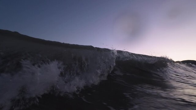 Twilight Ocean Waves Rolling Toward Camera, Gentle Swell Cresting Under Violet Sky With Single Star Overhead, Reflective Water Surface, Foamy Crest