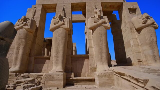 Ruins of Ramesseum mortuary temple with giant Ramesses II Osiride statues. It is located in the Theban necropolis in Upper Egypt, across the River Nile from the modern city of Luxor. Egypt.