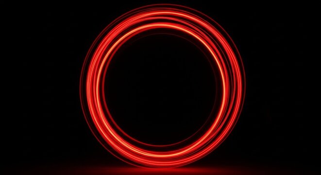 A long exposure photograph showing a perfect circle of glowing red light trails against a pitch-black background.