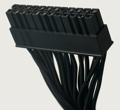 black 24-pin atx motherboard power connector isolated white background, macro closeup view