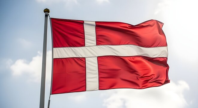 denmark flag waving on pole with blue sky and clouds