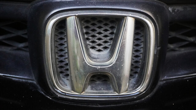 Purwokerto, Indonesia - 17 March 2026: Close-up of a car front grille badge with chrome logo detail on a black vehicle exterior.
