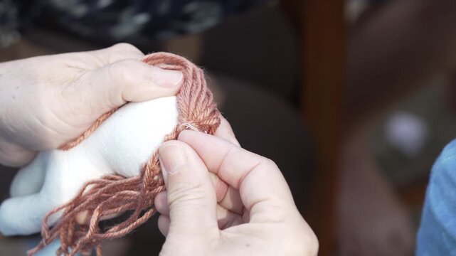 Close Up of Hands Skillfully Knitting Brown Yarn Showcasing Intricate Crafting Process and Textile Needlework with Cozy Yarn Texture