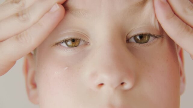 teenage boy applying acne cream, Teen boy focused on facial skincare, highlighting self-image issues and teenage skin concerns