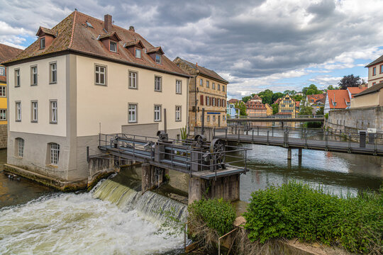 Bamberg, Germany - May 23, 2025: The Staustufe Brudermuhle, a historic weir located on the left arm of the Regnitz River, near the Muhlviertel district and the Geyersworthsteg footbridge. UNESCO WHS.