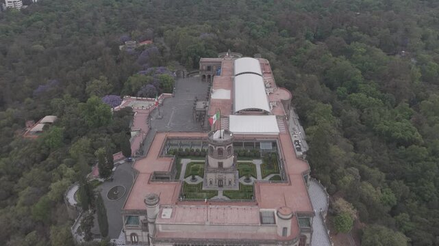 Aerial drone flying forward over Castillo de Chapultepec surrounded by forest at sunrise in Bosque de Chapultepec, M&eacute;xico City. Shot in D-Log M