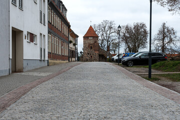 Fototapeta premium Historic medieval round tower at the end of a cobblestone street in a small European town