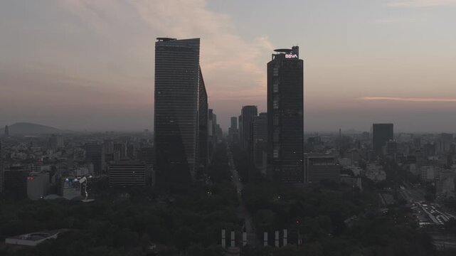 Aerial drone flying forward from Castillo de Chapultepec towards Paseo de la Reforma skyline at sunrise in M&eacute;xico City. Shot in D-Log M