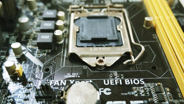 Purwokerto, Indonesia - 17 March 2026: Detailed view of an empty CPU socket on a PC motherboard beside RAM slots and UEFI BIOS label.