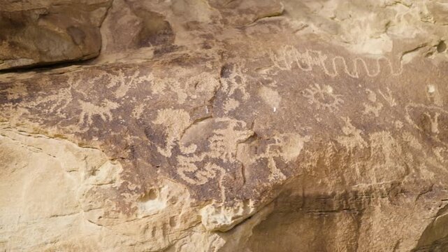 Native American Rock Art Petroglyphs on Sandstone Cliff Wall Slow Pan