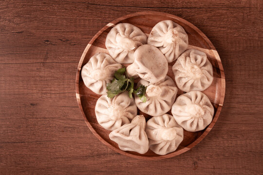 khinkali, on a wooden plate, Georgian traditional dish, on a wooden table, no people,