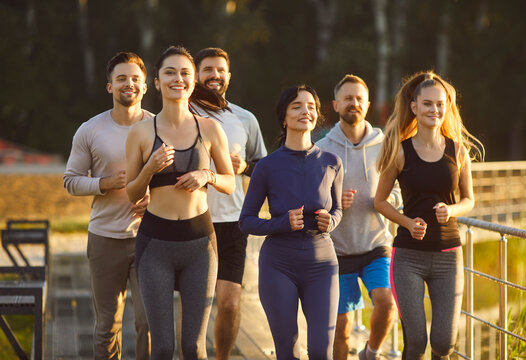 Athlete runners team jogs together during outdoor training, enhancing group sport, building fitness through running, connecting members in synchronized group workout and jogging across a open terrain.