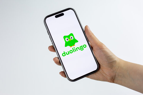 Moscow, Russia, March 14, 2026: Hand holding smartphone displaying green Duolingo owl logo on screen, isolated. Visual for news about platform updates, user growth and company strategy