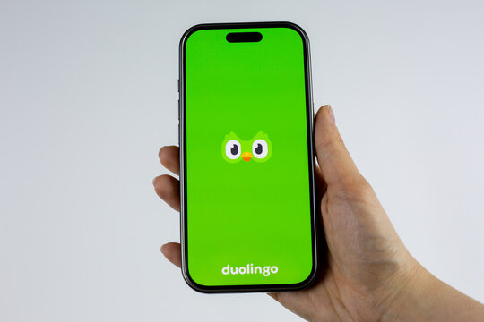 Moscow, Russia, March 14, 2026: Smartphone in hand showing green Duolingo logo with owl on display. Number one educational app and most popular language learning platform