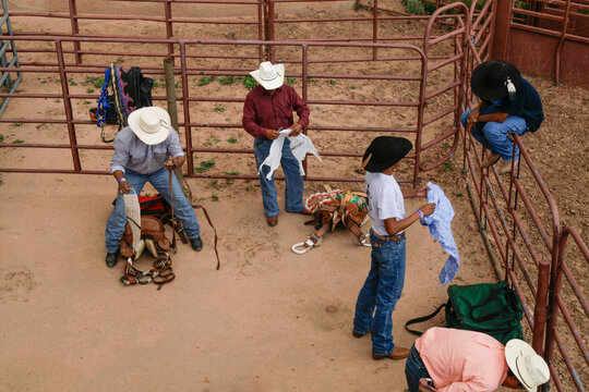 Cowboys preparing gear at a western rodeo