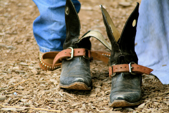 Santa Fe, New Mexico, United States. Cowboy boots with spurs standing on dirt rodeo ground