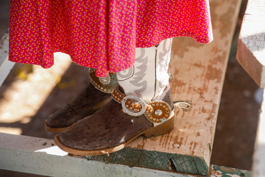 Leather boot with silver concha detail beneath colorful skirt