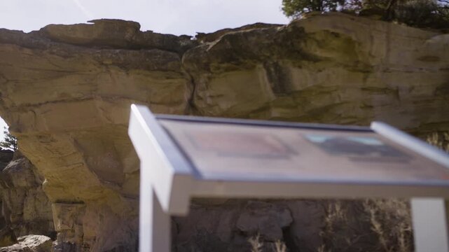 Information Sign at Rock Art Site with Cliffs in Background