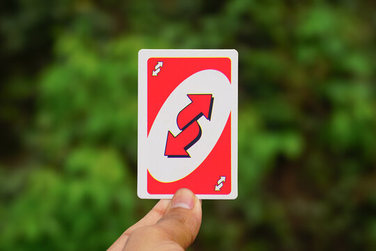 Hand Holding a Red Uno Reverse Card