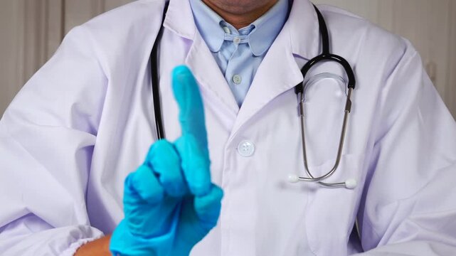 Un m&eacute;decin faisant le signe non avec un doigt. Il est habill&eacute; en blouse blanche et porte un st&eacute;thoscope. 