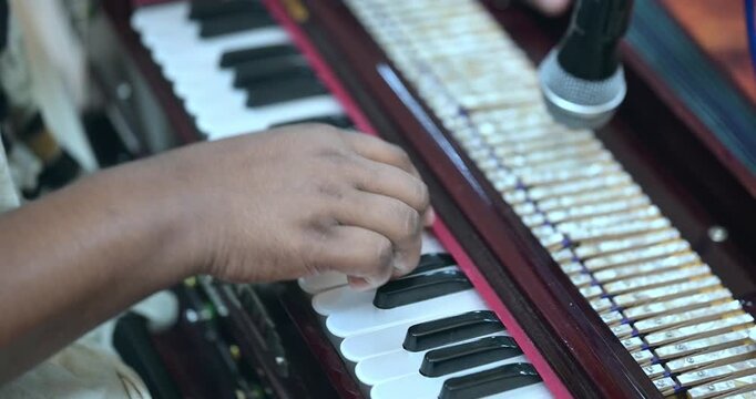 Close-up of harmonium playing during bhajan, showcasing rhythm, melody, and traditional Indian devotional music performance