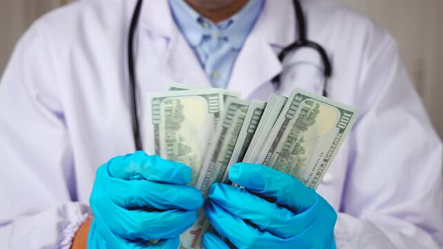 Un m&eacute;decin en blouse blanche et st&eacute;thoscope, avec des gants en nitrile bleu, qui tient des billets de banque dans ses mains, signifiant les frais m&eacute;dicaux.